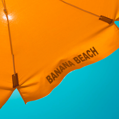 Detail of an yellow beach umbrella against a sunny blue sky.